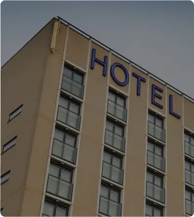 Facade of a hotel building with large blue "HOTEL" sign.
