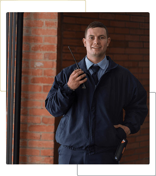 Security guard holding a walkie-talkie indoors.