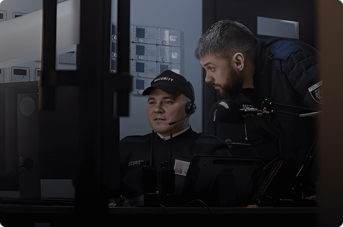Security officers monitoring surveillance screens together.