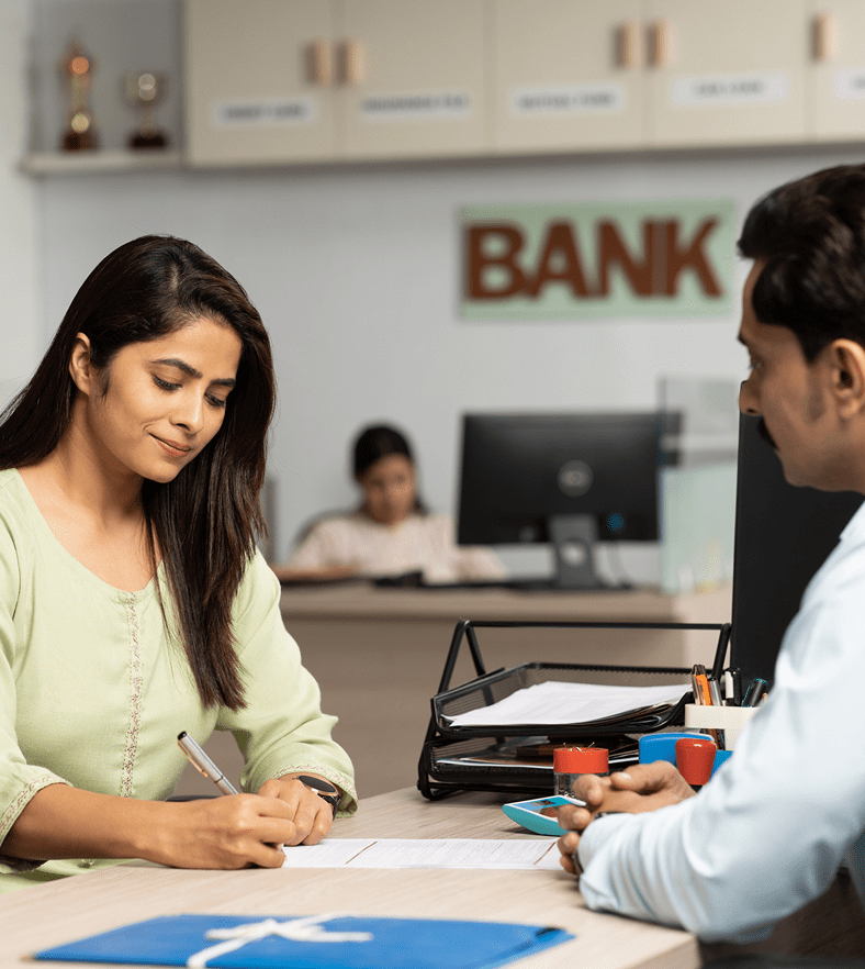 Woman discussing finances with a bank officer across the desk.